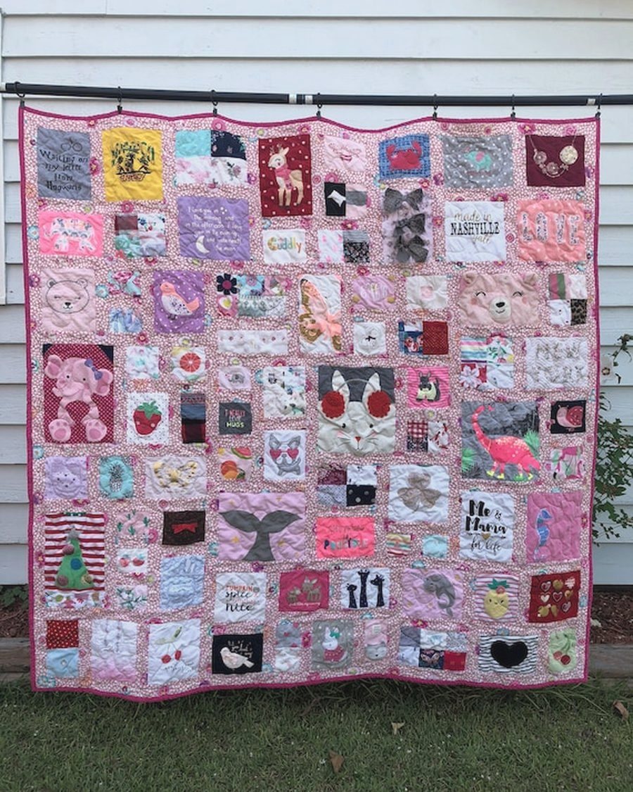 A memory quilt made from a collection of preloved garments, laid out in full