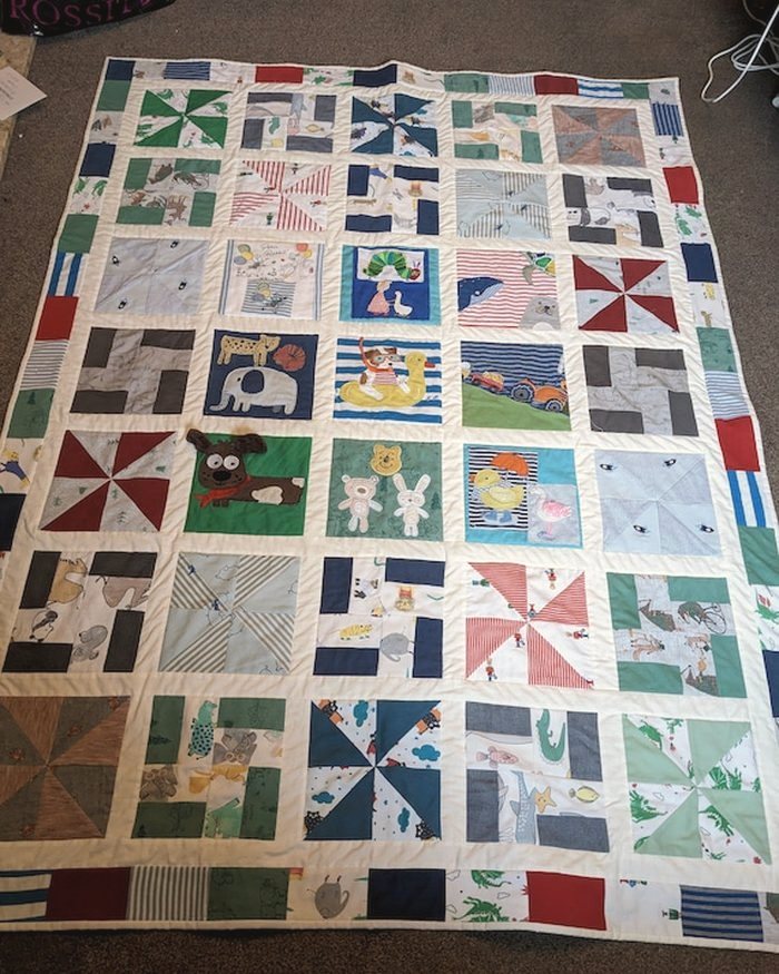 A patchwork quilt laid out flat showing many different fabrics